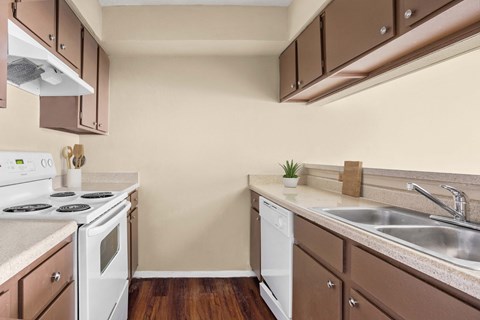 A kitchen with brown cabinets and a white stove.