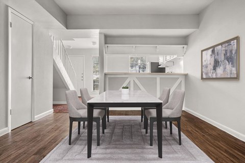 A dining room with a table and chairs.