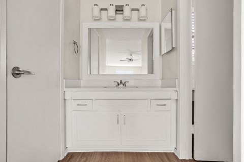 A white bathroom with a mirror and a sink.