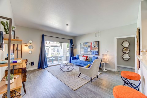 A living room with a blue couch and a white chair.