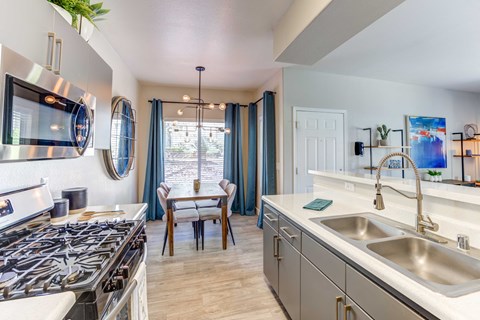 A modern kitchen with a stove top oven and a sink.