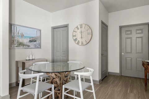 A dining room with a glass table and chairs.