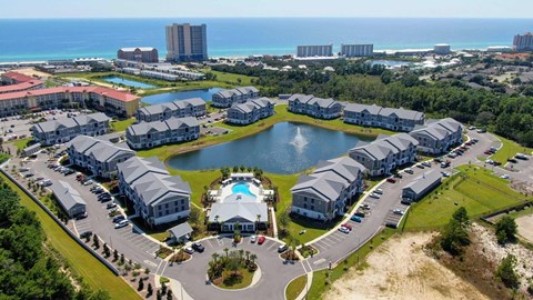 A resort with a large pool and a view of the ocean.