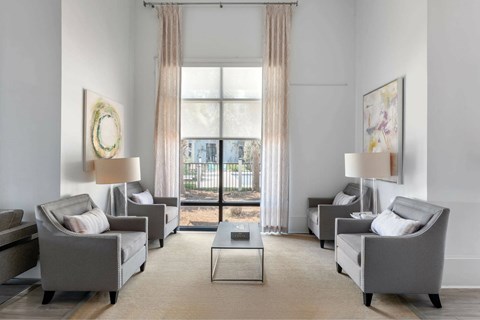 A living room with grey couches and a large window.