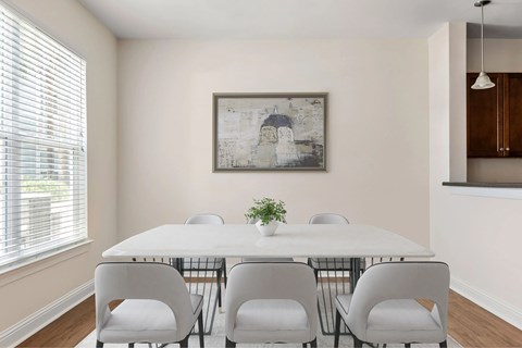 A dining room with a white table and chairs.