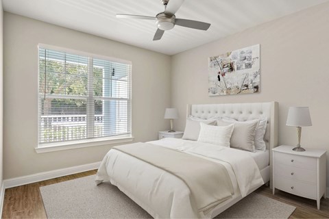 A bedroom with a window and ceiling fan.