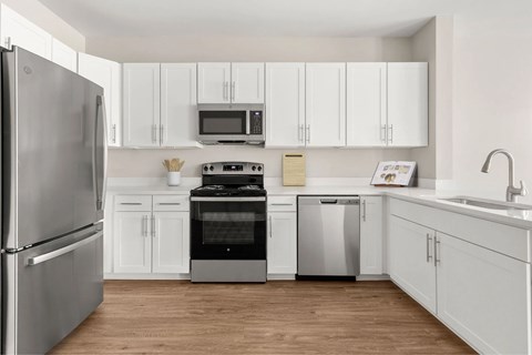 A kitchen with white cabinets and a stainless steel refrigerator.