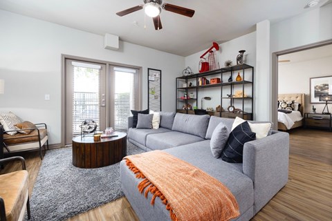 A living room with a grey couch and a wooden coffee table.