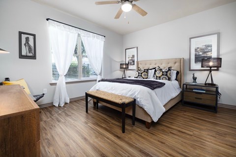 A bedroom with a bed, nightstand, and window.