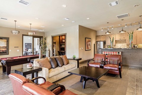 A living room with a pool table and leather chairs.