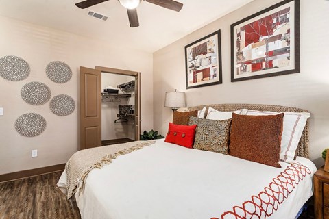 A bedroom with a large bed and a ceiling fan.