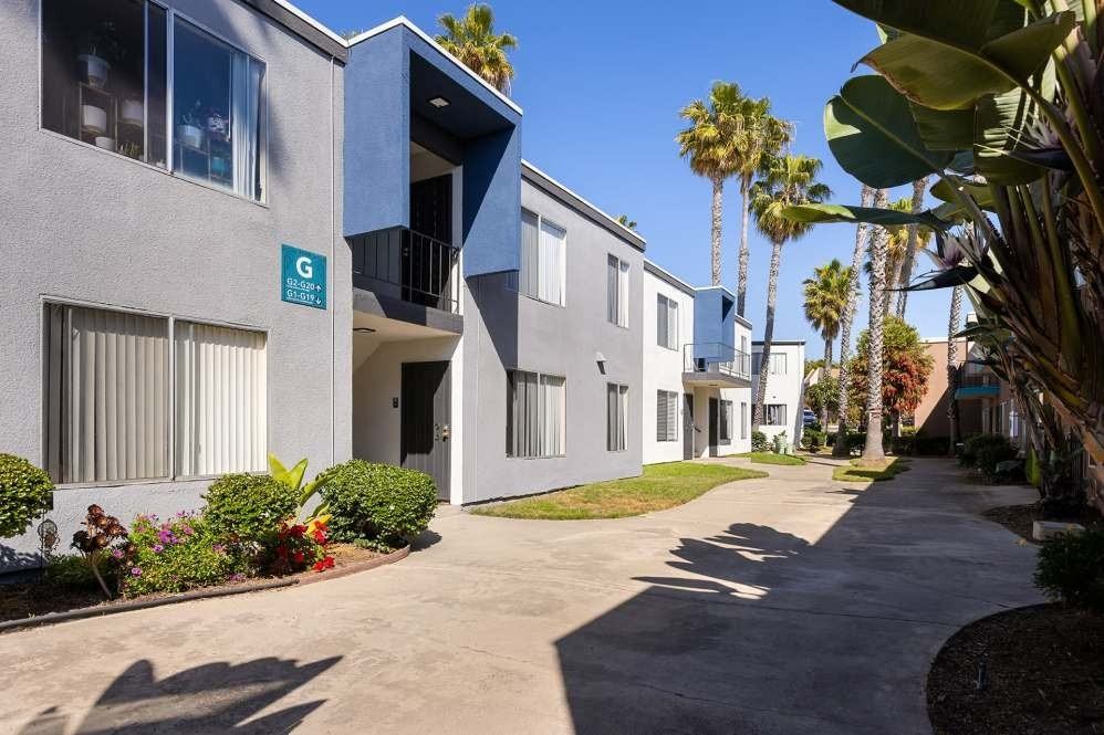 A sunny day at the G Street Apartments with a clear blue sky and palm trees.