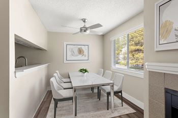 A dining room with a white table and chairs.