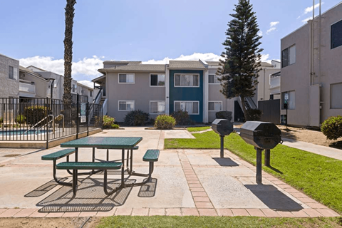 A green picnic table is in the middle of a courtyard.