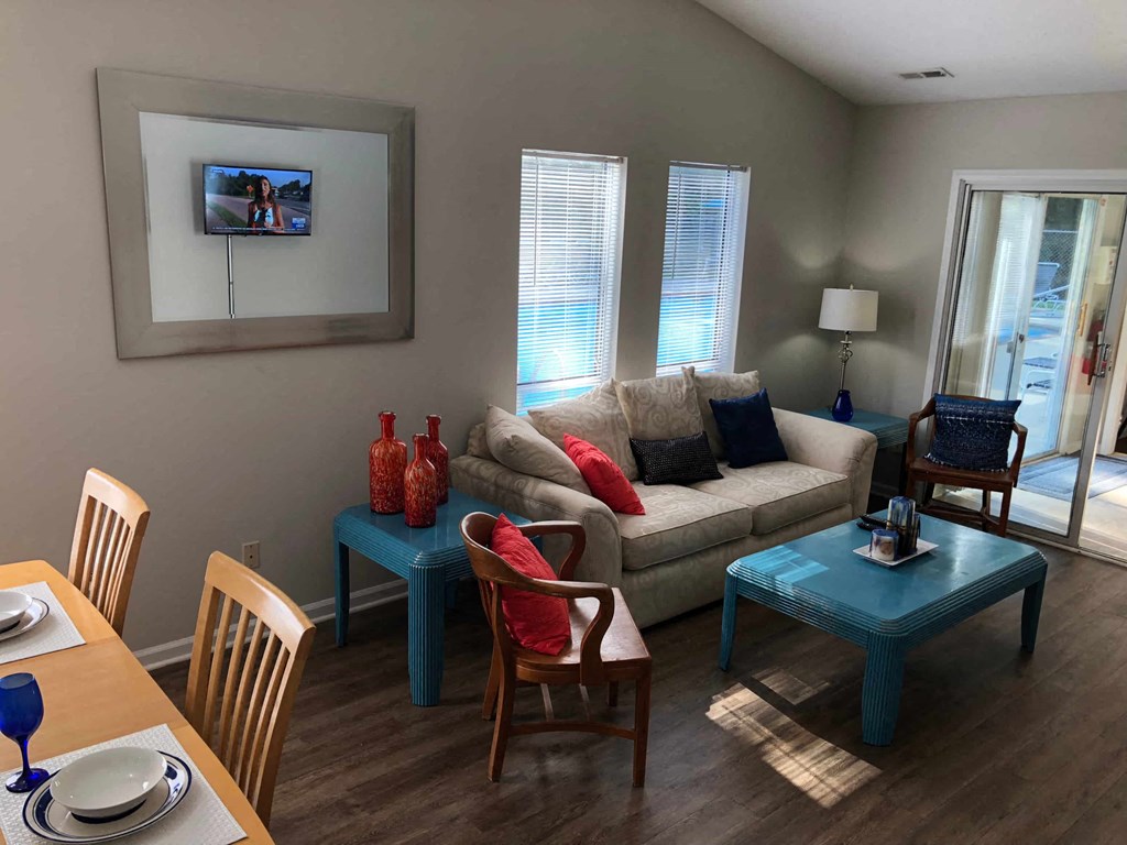 A living room with a couch, chairs, and a television.