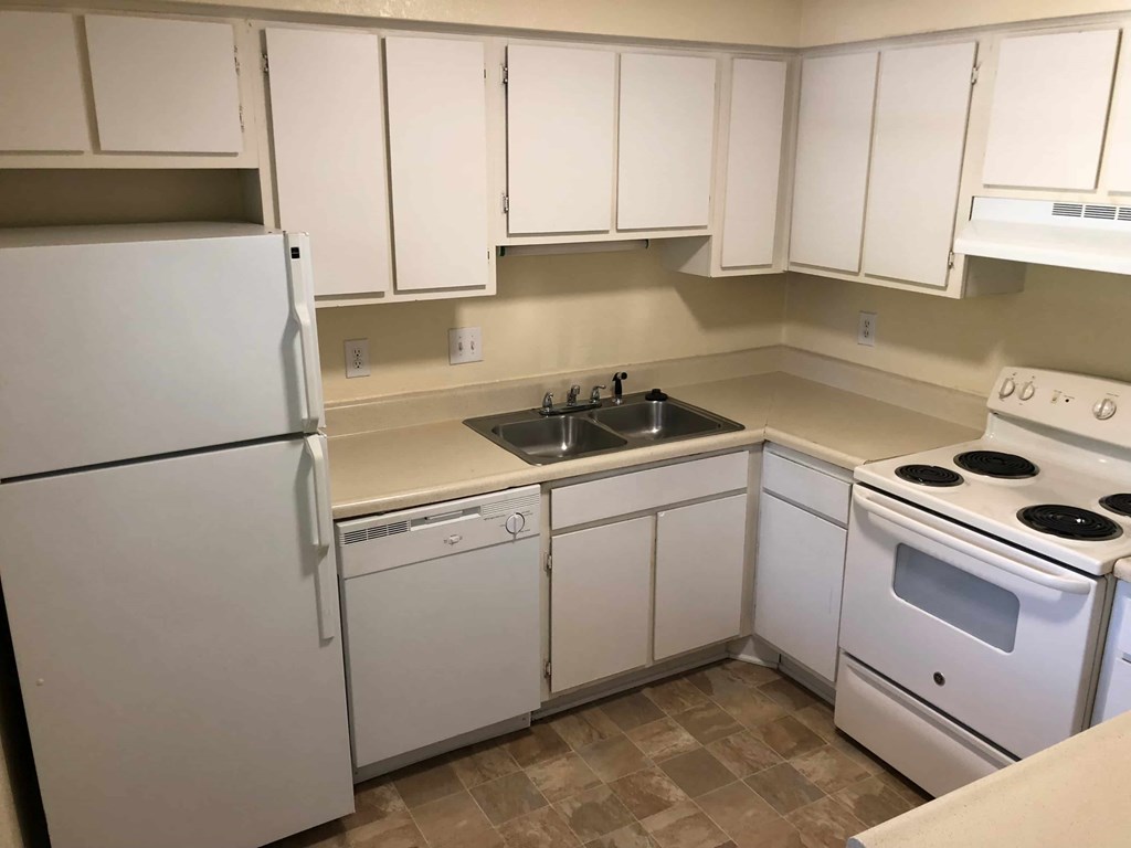 A kitchen with white appliances and cabinets.