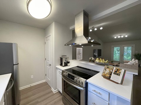 A modern kitchen with a stove top oven and a refrigerator.
