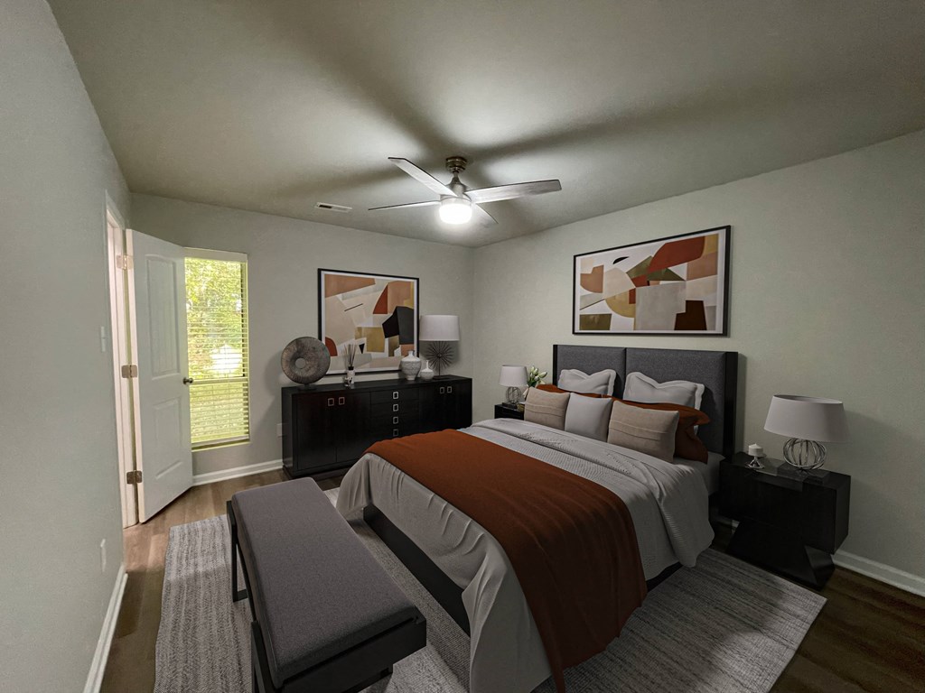 A bedroom with a bed, nightstand, and a ceiling fan.