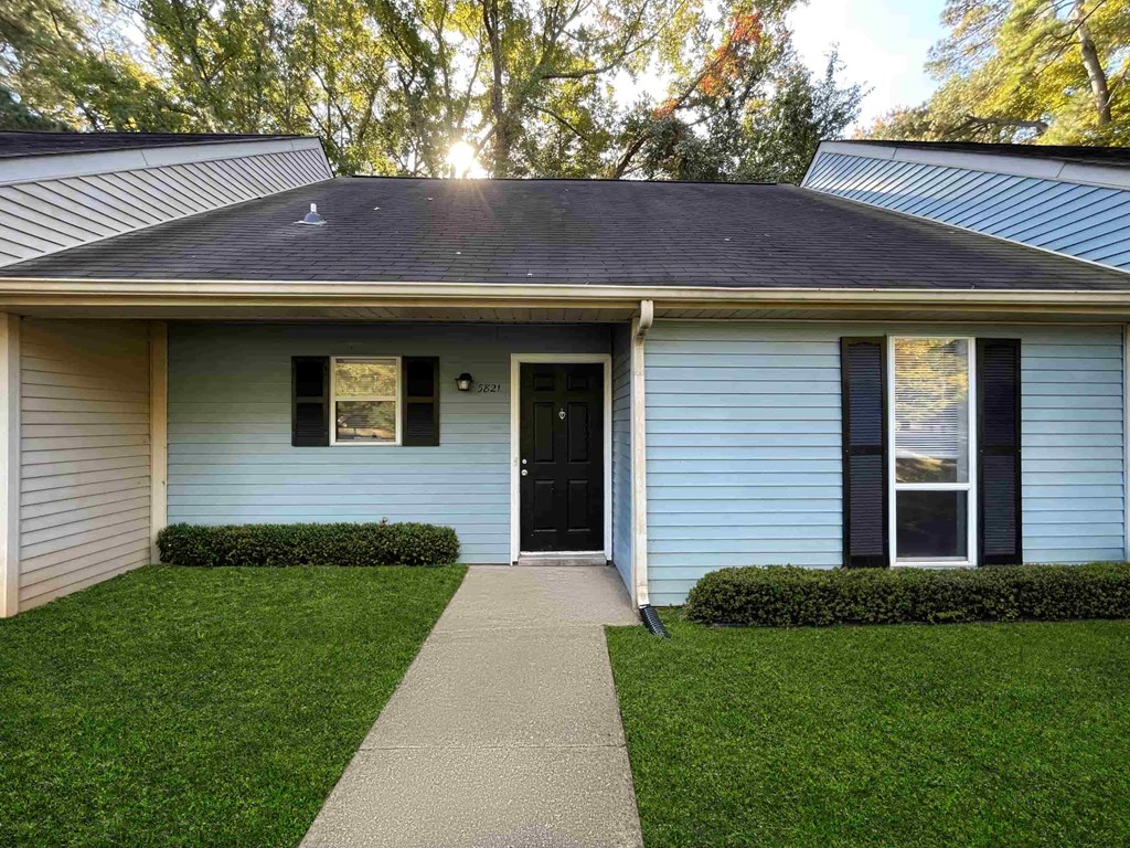 A house with a blue siding and a black door.