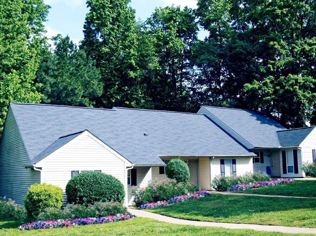 A house with a grey roof and a garden in front.