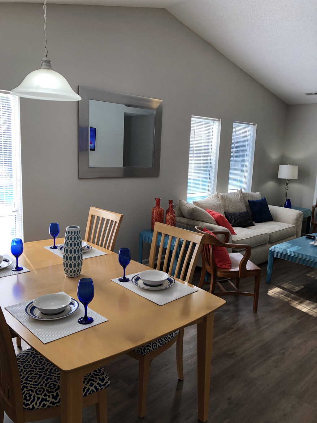 A dining room with a wooden table set for two.