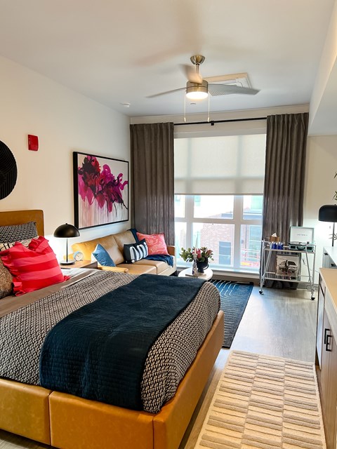 A bedroom with a large bed and a painting on the wall.