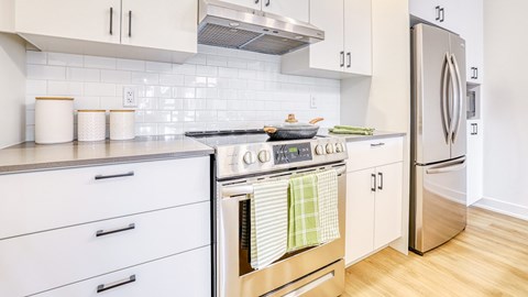 A kitchen with a stove top oven and a refrigerator.