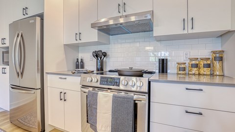 A modern kitchen with a stove top oven and a refrigerator.