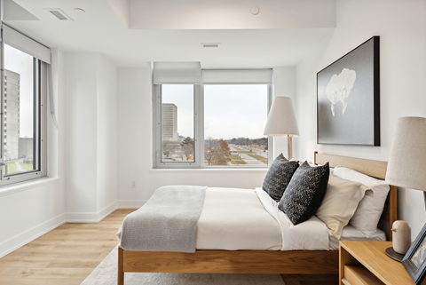 A bedroom with a large bed and a view of the city.