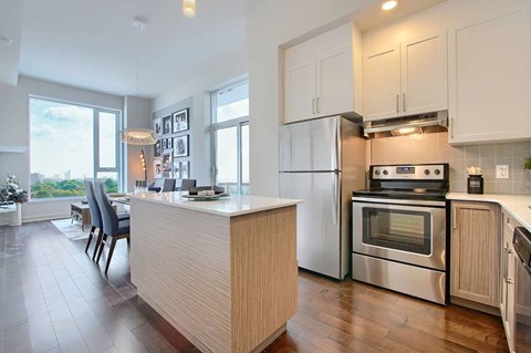 A modern kitchen with a wooden island and stainless steel appliances.