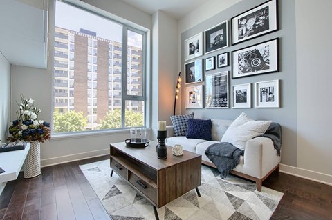 A living room with a couch, coffee table, and pictures on the wall.
