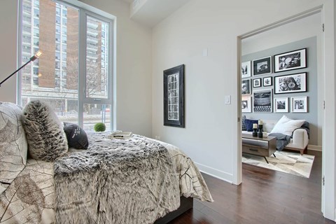A bedroom with a large bed and a picture frame on the wall.