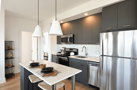 A modern kitchen with a white table and black cabinets.