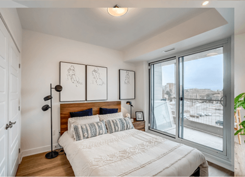 A bedroom with a large bed and a view of the outside.
