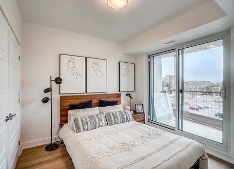 A bedroom with a large bed and a view of the outside.