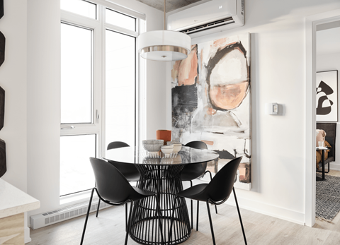 A modern dining room with a large abstract painting on the wall.