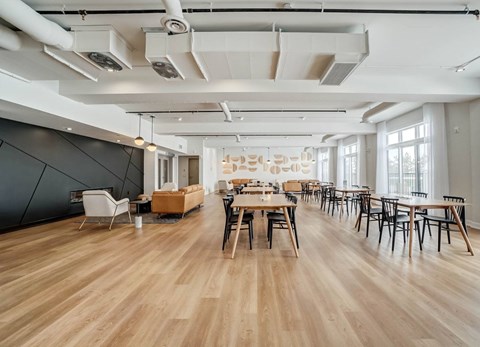 A spacious room with wooden floors and tables set up for a meeting.