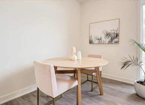 A dining room with a table and chairs.
