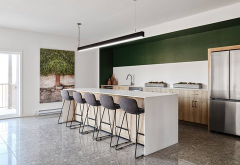 A modern kitchen with a bar area and stools at Champlain Village Urbain Apartments , Gatineau, Quebec