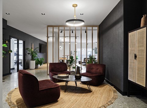 A modern living room with a large rug and a round table with four chairs.