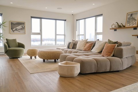 A modern living room with a large sectional sofa and a green armchair.