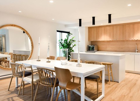 A modern dining room with a white table and chairs.