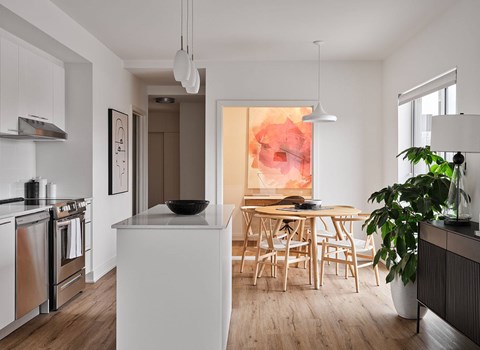 A modern kitchen with a white island and wooden chairs. at Château golf, Gatineau Quebec
