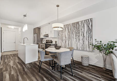 A modern kitchen with a dining table and chairs.