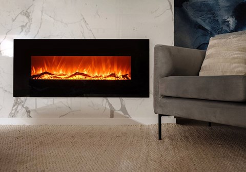 A modern fireplace with a grey couch in front of it.