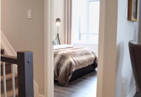 A bedroom with a bed and a chair.