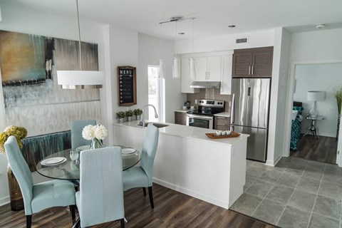 A modern kitchen with a dining table set for four.