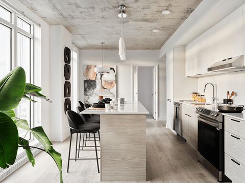 A modern kitchen with a dining area and a plant. at Le ColumbiaApartments , Gatineau, Quebec