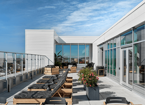 A modern outdoor dining area with wooden tables and chairs.