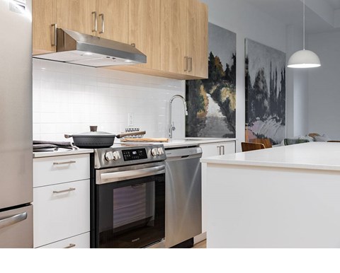 A modern kitchen with a stainless steel oven and white countertops.